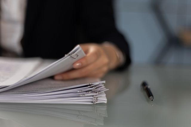 person holding a stack of papers